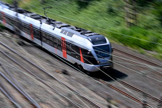 A regional train drives past the freight station in Hagen, western Germany on June 24, 2026, the day after a breakdown in the railway radio communication system brought trains across the country to a standstill. A disruption in the digital radio network temporarily brought rail traffic across Germany to a standstill overnight. In addition to long-distance and regional services, private rail operators and S-Bahn (suburban rail) services in various cities were also affected. On June 24, the company stated that train services in Germany had resumed "largely without disruption" that morning. However, "isolated disruptions may still occur." Passengers are advised to check their connections. (Photo by Ina FASSBENDER / AFP)
