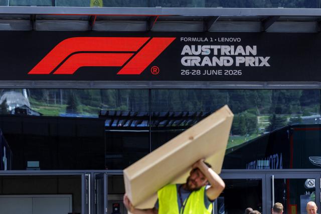 A worker carries a package during preparations and contruction work at the paddock of the Red Bull Ring race track in Spielberg, Austria on June 24, 2026, ahead of the Formula One Austrian Grand Prix. (Photo by ERWIN SCHERIAU / APA / AFP) / Austria OUT