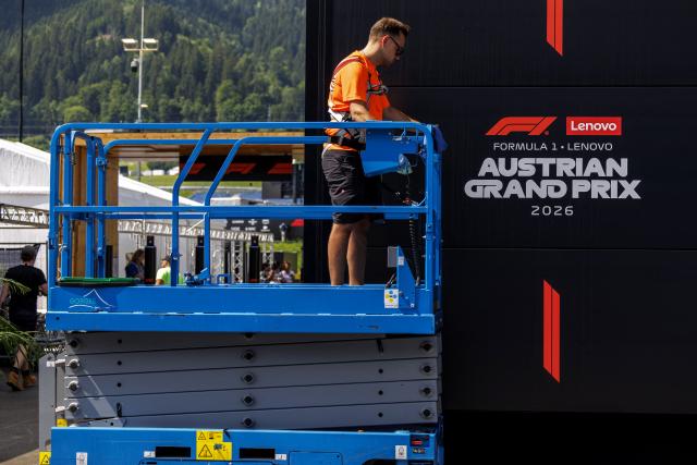 A worker stands on a hydraulic platform during preparations and contruction work at the paddock of the Red Bull Ring race track in Spielberg, Austria on June 24, 2026, ahead of the Formula One Austrian Grand Prix. (Photo by ERWIN SCHERIAU / APA / AFP) / Austria OUT