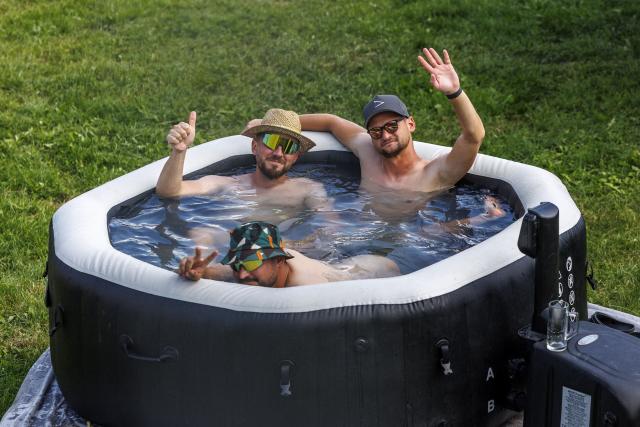 TOPSHOT - Formula One fans refresh in a mini-pool on a camping site near the Red Bull Ring race track in Spielberg, Austria on June 24, 2026, ahead of the Formula One Austrian Grand Prix. (Photo by ERWIN SCHERIAU / APA / AFP) / Austria OUT