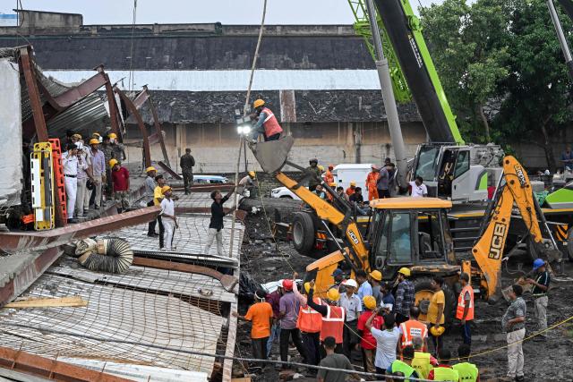 Rescue workers search for survivors and victims following a collapse at an under-construction warehouse in Kolkata's Taratala area on June 24, 2026. (Photo by Dibyangshu SARKAR / AFP)