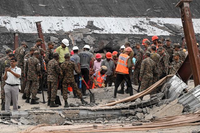 Rescue workers search for survivors and victims following a collapse at an under-construction warehouse in Kolkata's Taratala area on June 24, 2026. (Photo by Dibyangshu SARKAR / AFP)