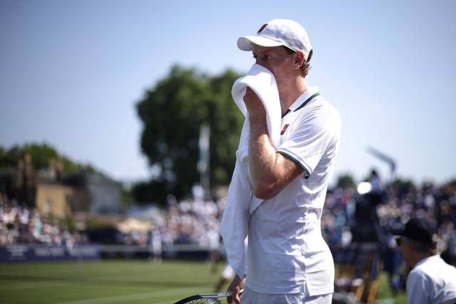 Italy's Jannik Sinner wipes sweat from his face during a break in play against Britain's Cameron Norrie during their men's singles exhibition match during the Giorgio Armani Tennis Classic tournament at the Hurlingham Club in London on June 24, 2026. (Photo by Henry NICHOLLS / AFP)