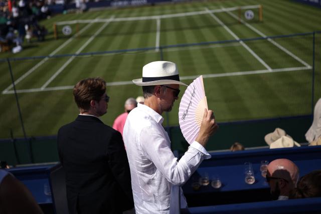 A spectator uses a hand fan during the Giorgio Armani Tennis Classic tournament at the Hurlingham Club in London on June 24, 2026. (Photo by Henry NICHOLLS / AFP)