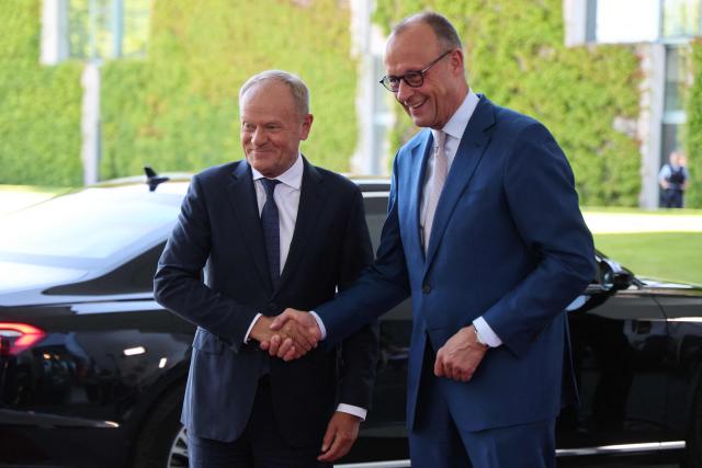 German Chancellor Friedrich Merz (R) welcomes Polish Prime Minister Donald Tusk as he arrives for a meeting with state leaders of the European Group of Five (E5) and the NATO Secretary General on June 24, 2026 at the Chancellery in Berlin, Germany. (Photo by Ludovic MARIN / AFP)