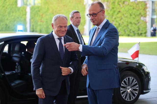 German Chancellor Friedrich Merz (R) welcomes Polish Prime Minister Donald Tusk as he arrives for a meeting with state leaders of the European Group of Five (E5) and the NATO Secretary General on June 24, 2026 at the Chancellery in Berlin, Germany. (Photo by Ludovic MARIN / AFP)