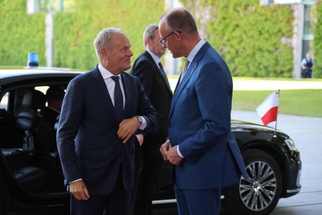 German Chancellor Friedrich Merz (R) welcomes Polish Prime Minister Donald Tusk as he arrives for a meeting with state leaders of the European Group of Five (E5) and the NATO Secretary General on June 24, 2026 at the Chancellery in Berlin, Germany. (Photo by Ludovic MARIN / AFP)