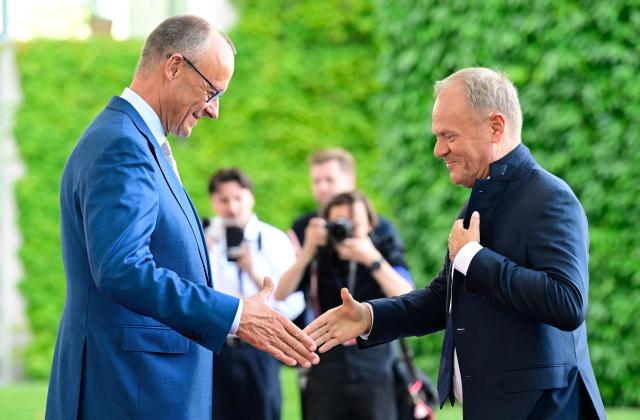 German Chancellor Friedrich Merz (L) welcomes Polish Prime Minister Donald Tusk as he arrives for a meeting with state leaders of the European Group of Five (E5) and the NATO Secretary General on June 24, 2026 at the Chancellery in Berlin, Germany. (Photo by John MACDOUGALL / AFP)