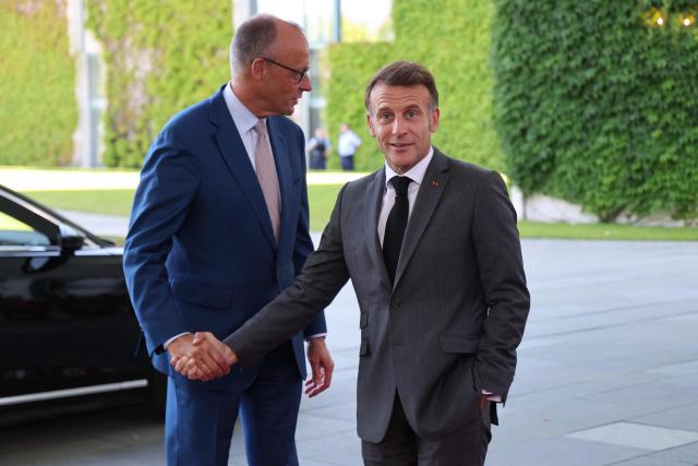 German Chancellor Friedrich Merz (L) welcomes France's President Emmanuel Macron as he arrives for a meeting with state leaders of the European Group of Five (E5) and the NATO Secretary General on June 24, 2026 at the Chancellery in Berlin, Germany. (Photo by Ludovic MARIN / AFP)