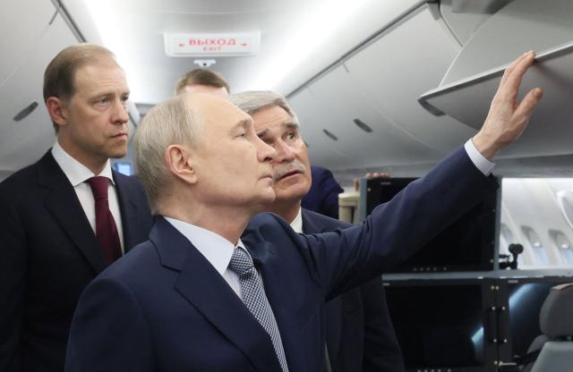 In this pool photograph distributed by the Russian state agency Sputnik, Russia's President Vladimir Putin inspects a Yakovlev SJ-100 short-haul jet aircraft at the Flight Research Institute named after M.M. Gromov in Zhukovsky in the Moscow region on June 24, 2026. (Photo by Mikhail METZEL / POOL / AFP)