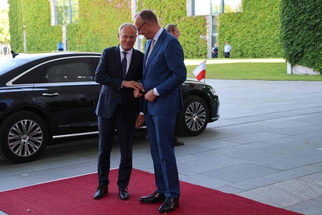 German Chancellor Friedrich Merz (R) welcomes Polish Prime Minister Donald Tusk as he arrives for a meeting with state leaders of the European Group of Five (E5) and the NATO Secretary General on June 24, 2026 at the Chancellery in Berlin, Germany. (Photo by Ludovic MARIN / AFP)