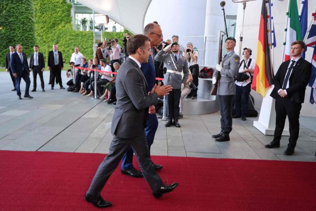 German Chancellor Friedrich Merz welcomes France's President Emmanuel Macron as he arrives for a meeting with state leaders of the European Group of Five (E5) and the NATO Secretary General on June 24, 2026 at the Chancellery in Berlin, Germany. (Photo by Ludovic MARIN / AFP)