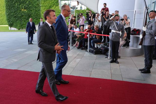 German Chancellor Friedrich Merz (L) welcomes France's President Emmanuel Macron as he arrives for a meeting with state leaders of the European Group of Five (E5) and the NATO Secretary General on June 24, 2026 at the Chancellery in Berlin, Germany. (Photo by Ludovic MARIN / AFP)