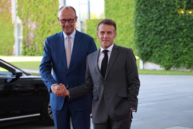 German Chancellor Friedrich Merz (L) welcomes France's President Emmanuel Macron as he arrives for a meeting with state leaders of the European Group of Five (E5) and the NATO Secretary General on June 24, 2026 at the Chancellery in Berlin, Germany. (Photo by Ludovic MARIN / AFP)