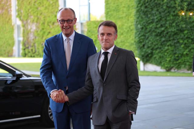 German Chancellor Friedrich Merz (L) welcomes France's President Emmanuel Macron as he arrives for a meeting with state leaders of the European Group of Five (E5) and the NATO Secretary General on June 24, 2026 at the Chancellery in Berlin, Germany. (Photo by Ludovic MARIN / AFP)