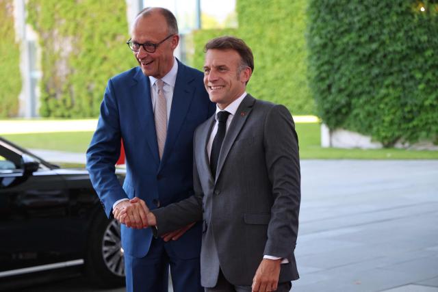 German Chancellor Friedrich Merz (L) welcomes France's President Emmanuel Macron as he arrives for a meeting with state leaders of the European Group of Five (E5) and the NATO Secretary General on June 24, 2026 at the Chancellery in Berlin, Germany. (Photo by Ludovic MARIN / AFP)