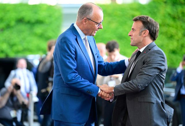 German Chancellor Friedrich Merz (L) welcomes France's President Emmanuel Macron as he arrives for a meeting with state leaders of the European Group of Five (E5) and the NATO Secretary General on June 24, 2026 at the Chancellery in Berlin, Germany. (Photo by John MACDOUGALL / AFP)