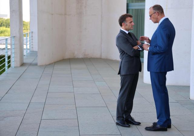 German Chancellor Friedrich Merz (R) and French President Emmanuel Macron talk on the terrace of the Chancellery at the start of the meeting of State leaders of the European Group of Five (E5) and the NATO Secretary General on June 24, 2026 at the Chancellery in Berlin, Germany. (Photo by Ludovic MARIN / AFP)