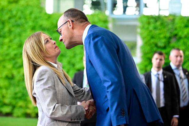 German Chancellor Friedrich Merz (R) welcomes Italy's Prime Minister Giorgia Meloni as he arrives for a meeting with state leaders of the European Group of Five (E5) and the NATO Secretary General on June 24, 2026 at the Chancellery in Berlin, Germany. (Photo by Tobias SCHWARZ / AFP)