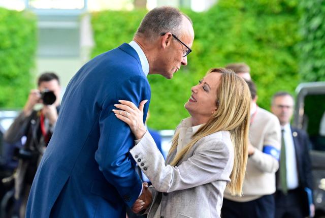German Chancellor Friedrich Merz (L) welcomes Italy's Prime Minister Giorgia Meloni as she arrives for a meeting with state leaders of the European Group of Five (E5) and the NATO Secretary General on June 24, 2026 at the Chancellery in Berlin, Germany. (Photo by John MACDOUGALL / AFP)