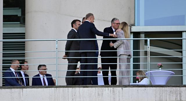 Britain's Prime Minister Keir Starmer (2nd R) greets Italy's Prime Minister Giorgia Meloni (R) as (L-R) France's President Emmanuel Macron, German Chancellor Friedrich Merz (hidden) and Polish Prime Minister Donald Tusk look on as they stand on a terrace of the Chancellery at the start of a meeting with state leaders of the European Group of Five (E5) and the NATO Secretary General on June 24, 2026 at the Chancellery in Berlin, Germany. (Photo by Tobias SCHWARZ / AFP)
