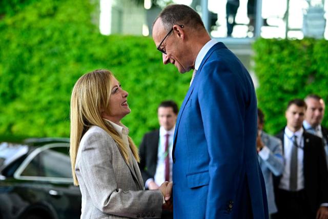German Chancellor Friedrich Merz (R) welcomes Italy's Prime Minister Giorgia Meloni as he arrives for a meeting with state leaders of the European Group of Five (E5) and the NATO Secretary General on June 24, 2026 at the Chancellery in Berlin, Germany. (Photo by Tobias SCHWARZ / AFP)