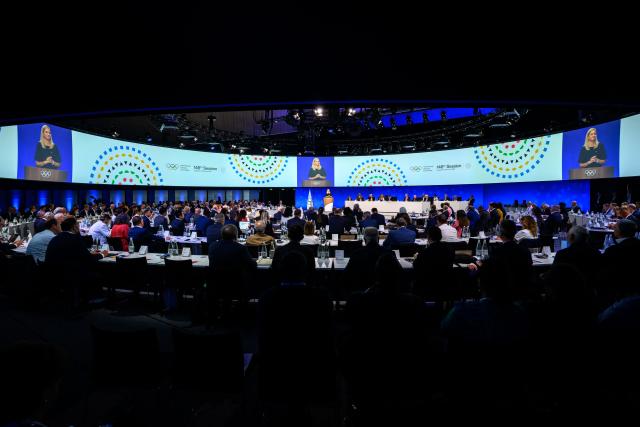 International Olympic Committee President (IOC) Kirsty Coventry is seen on a giant screen at the opening of an IOC session, in Lausanne, on June 24, 2026. (Photo by Fabrice COFFRINI / AFP)