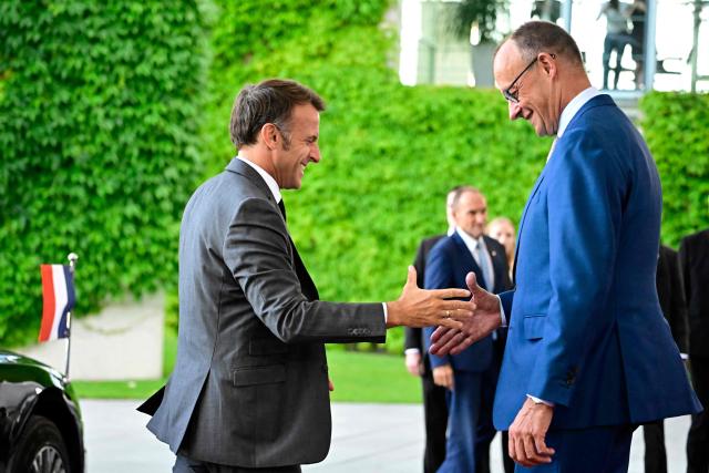 German Chancellor Friedrich Merz (R) welcomes France's President Emmanuel Macron as he arrives for a meeting with state leaders of the European Group of Five (E5) and the NATO Secretary General on June 24, 2026 at the Chancellery in Berlin, Germany. (Photo by Tobias SCHWARZ / AFP)