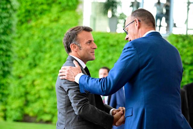 German Chancellor Friedrich Merz (L) welcomes France's President Emmanuel Macron as he arrives for a meeting with state leaders of the European Group of Five (E5) and the NATO Secretary General on June 24, 2026 at the Chancellery in Berlin, Germany. (Photo by Tobias SCHWARZ / AFP)