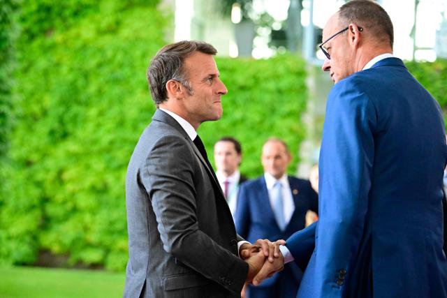 German Chancellor Friedrich Merz (L) welcomes France's President Emmanuel Macron as he arrives for a meeting with state leaders of the European Group of Five (E5) and the NATO Secretary General on June 24, 2026 at the Chancellery in Berlin, Germany. (Photo by Tobias SCHWARZ / AFP)