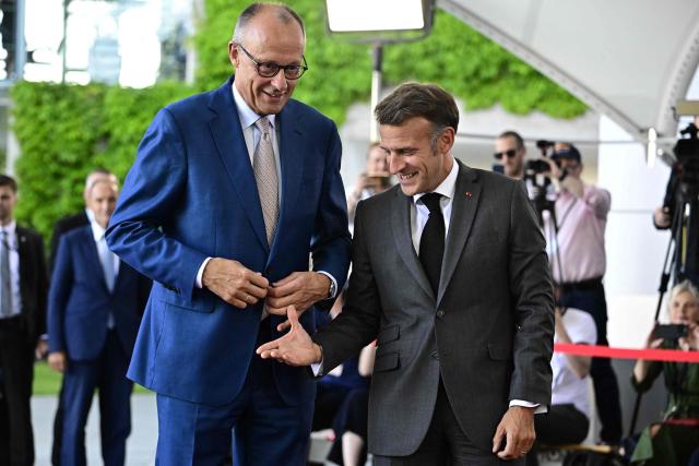 German Chancellor Friedrich Merz (L) welcomes France's President Emmanuel Macron as he arrives for a meeting with state leaders of the European Group of Five (E5) and the NATO Secretary General on June 24, 2026 at the Chancellery in Berlin, Germany. (Photo by Tobias SCHWARZ / AFP)