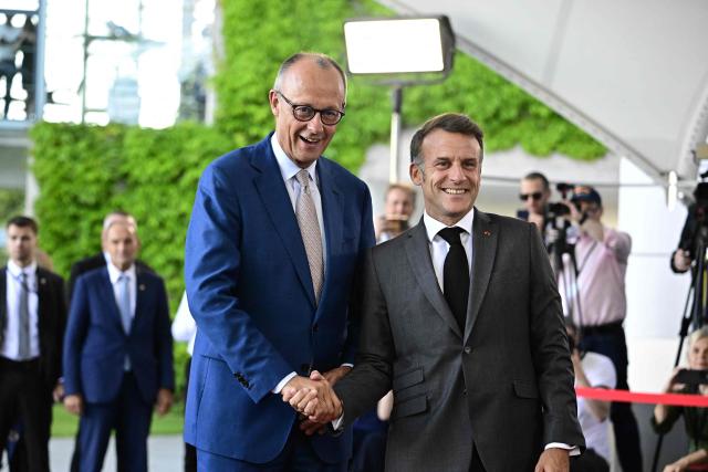 German Chancellor Friedrich Merz (L) welcomes France's President Emmanuel Macron as he arrives for a meeting with state leaders of the European Group of Five (E5) and the NATO Secretary General on June 24, 2026 at the Chancellery in Berlin, Germany. (Photo by Tobias SCHWARZ / AFP)