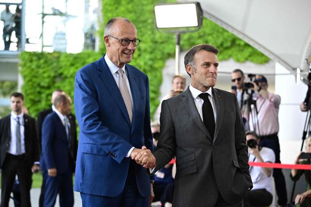 German Chancellor Friedrich Merz (L) welcomes France's President Emmanuel Macron as he arrives for a meeting with state leaders of the European Group of Five (E5) and the NATO Secretary General on June 24, 2026 at the Chancellery in Berlin, Germany. (Photo by Tobias SCHWARZ / AFP)