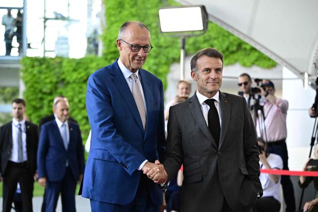 German Chancellor Friedrich Merz (L) welcomes France's President Emmanuel Macron as he arrives for a meeting with state leaders of the European Group of Five (E5) and the NATO Secretary General on June 24, 2026 at the Chancellery in Berlin, Germany. (Photo by Tobias SCHWARZ / AFP)