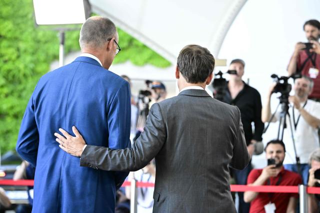 German Chancellor Friedrich Merz (L) welcomes France's President Emmanuel Macron as he arrives for a meeting with state leaders of the European Group of Five (E5) and the NATO Secretary General on June 24, 2026 at the Chancellery in Berlin, Germany. (Photo by Tobias SCHWARZ / AFP)