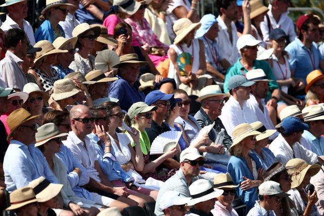 Spectators use hand fans and wear summer hats during the Giorgio Armani Tennis Classic tournament at the Hurlingham Club in London on June 24, 2026. (Photo by Henry Nicholls / AFP)