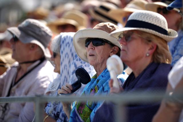 Spectators use portable fans during the Giorgio Armani Tennis Classic tournament at the Hurlingham Club in London on June 24, 2026. (Photo by Henry NICHOLLS / AFP)