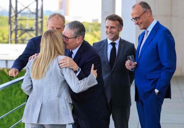 Britain's Prime Minister Keir Starmer (C) hugs Italy's Prime Minister Giorgia Meloni, as Poland's Prime Minister Donald Tusk (L), France's President Emmanuel Macron and Germany's Chancellor Friedrich Merz (R) watch on the terrace of the Chancellery at the start of the meeting of State leaders of the European Group of Five (E5) and the NATO Secretary General on June 24, 2026 at the Chancellery in Berlin, Germany. (Photo by Ludovic MARIN / AFP)
