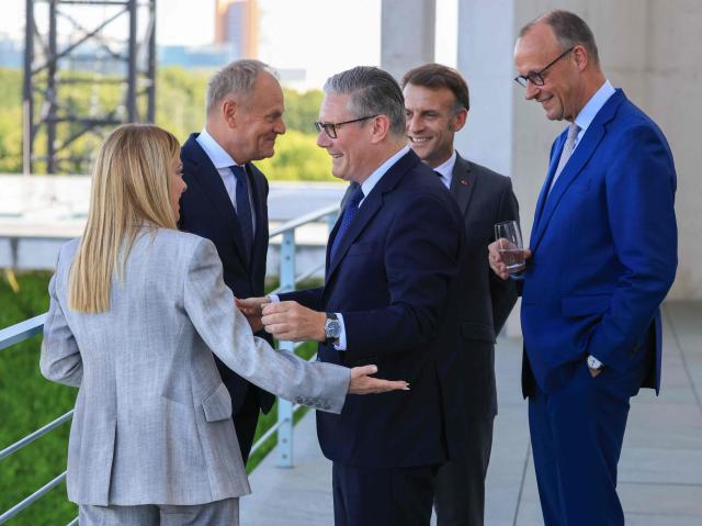 Britain's Prime Minister Keir Starmer (C) hugs Italy's Prime Minister Giorgia Meloni, as Poland's Prime Minister Donald Tusk (L), France's President Emmanuel Macron and Germany's Chancellor Friedrich Merz (R) watch on the terrace of the Chancellery at the start of the meeting of State leaders of the European Group of Five (E5) and the NATO Secretary General on June 24, 2026 at the Chancellery in Berlin, Germany. (Photo by Ludovic MARIN / AFP)