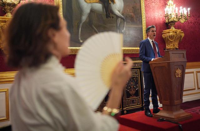 A woman uses a fan to keep cool as Britain's Climate Change and Net Zero Secretary Ed Miliband speaks at a London Climate Week reception, hosted by the Department for Energy Security and Net Zero (DESNZ), at St James's Palace, London on June 24, 2026. (Photo by Yui Mok / POOL / AFP)
