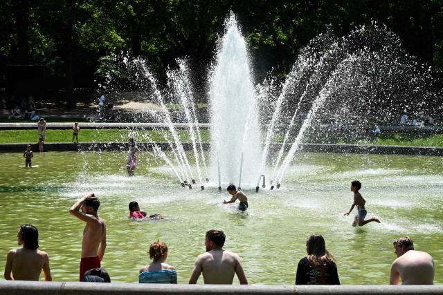 Children play in the water of a fountain to refresh themselves during a heatwave, in Brussels on June 24, 2026. (Photo by Nicolas TUCAT / AFP)