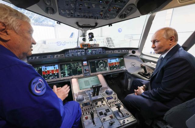 In this pool photograph distributed by the Russian state agency Sputnik, Russia's President Vladimir Putin inspects a Yakovlev MC-21 medium-haul airliner at the Flight Research Institute named after M.M. Gromov in Zhukovsky in the Moscow region on June 24, 2026. (Photo by Mikhail METZEL / POOL / AFP)