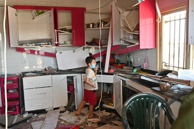 A Lebanese child stands inside the kitchen of the family home looking at the damage caused by Israeli military strikes, in the southern Lebanese village of Srifa on June 24, 2026. Israeli Defence Minister said June 24, that the United States has not demanded that Israel withdraw its troops from southern Lebanon, a condition set by Lebanon in ongoing ceasefire negotiations. Lebanese President rejected Israel's occupation of the south and foreign interference in his country's affairs -- an allusion to Hezbollah's backer Iran -- as a fifth round of Israel-Lebanon talks began in Washington on June 23. (Photo by FADEL itani / AFP) / 