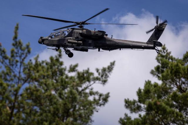 A Polish Air Forces US-made AH-6h Apache helicopter participates in a lake crossing, as troops from Poland and Lithuania take part in the "Bursztynowy Obronca-26" (Amber Defender) military exercise on the Orzysz military training ground, north-eastern Poland, on June 24, 2026 (Photo by Wojtek RADWANSKI / AFP)