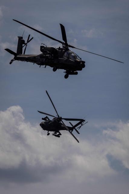 Two Polish Air Forces US-made AH-6h Apache helicopters participate in a lake crossing, as troops from Poland and Lithuania take part in the "Bursztynowy Obronca-26" (Amber Defender) military exercise on the Orzysz military training ground, north-eastern Poland, on June 24, 2026. (Photo by Wojtek RADWANSKI / AFP)