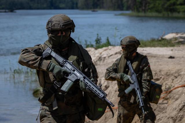 Polish soldiers are seen, as troops from Poland and Lithuania take part in the "Bursztynowy Obronca-26" (Amber Defender) military exercise on the Orzysz military training ground, north-eastern Poland, on June 24, 2026. (Photo by Wojtek RADWANSKI / AFP)