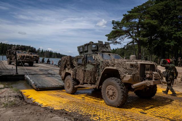 A Lithuanian Armed Forces US-made Oshkosh JLTV (Joint Light Tactical Vehicle) disembarks from the deck of a Polish Army PFM Motorised Floating Bridge during a lake crossing, as troops from Poland and Lithuania take part in the "Bursztynowy Obronca-26" (Amber Defender) military exercise on the Orzysz military training ground, north-eastern Poland, on June 24, 2026. (Photo by Wojtek RADWANSKI / AFP)