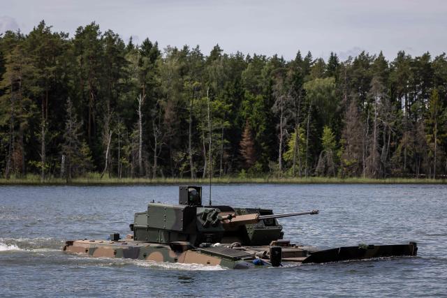 A Polish-made Borsuk amphibious Infantry Fighting Vehicle (IFV) crosses a lake, as troops from Poland and Lithuania take part in the "Bursztynowy Obronca-26" (Amber Defender) military exercise on the Orzysz military training ground, north-eastern Poland, on June 24, 2026. (Photo by Wojtek RADWANSKI / AFP)