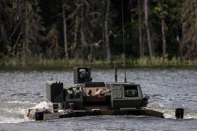 A Polish-made Borsuk amphibious Infantry Fighting Vehicle (IFV) crosses a lake, as troops from Poland and Lithuania take part in the "Bursztynowy Obronca-26" (Amber Defender) military exercise on the Orzysz military training ground, north-eastern Poland, on June 24, 2026. (Photo by Wojtek RADWANSKI / AFP)
