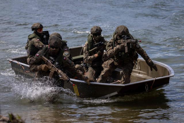 Polish soldiers disembark from a boat, as troops from Poland and Lithuania take part in the "Bursztynowy Obronca-26" (Amber Defender) military exercise on the Orzysz military training ground, north-eastern Poland, on June 24, 2026. (Photo by Wojtek RADWANSKI / AFP)
